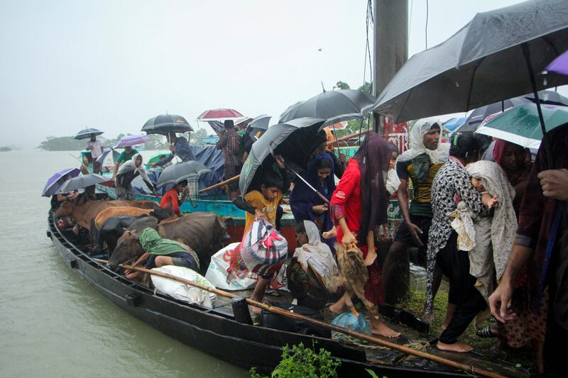 People prepare to leave a boat after being evacuated from a flooded area on the outskirts of Sylhet, Bangladesh. AFP