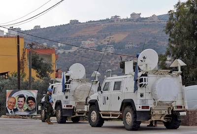 United Nations Interim Forces in Lebanon (UNIFIL) vehicles and armoured personnel carriers (APC) are seen on a road near the border between the southern Lebanese village of Kfar Kila and Israel on December 4, 2018, with a poster depicting Lebanese parliament speaker Nabih Berri (L), Syrian President Bashar al-Assad (C), and Hezbollah leader Hasan Nasrallah (R) seen in the corner. Israel's army said on December 4 it had detected Hezbollah "attack tunnels" infiltrating its territory from Lebanon and had launched an operation called "Northern Shield" to destroy them, a move likely to raise tensions with the Iran-backed group. / AFP / Ali DIA
