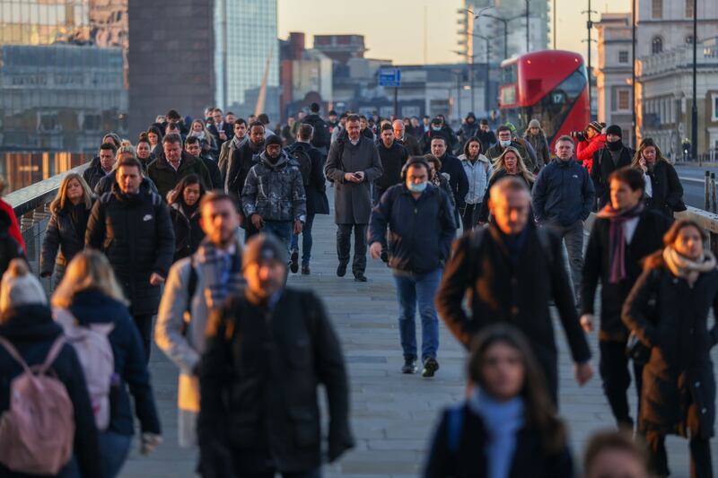 Morning commuters on London Bridge head towards the City of London. Britain's labour market grew strongly despite a surge in coronavirus infections late last year. Bloomberg