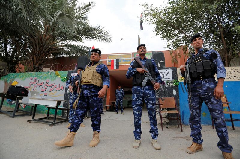 Iraqi security forces stand guard outside a polling station during the parliamentary election in the Sadr city district of Baghdad. Wissm al-Okili / Reuters