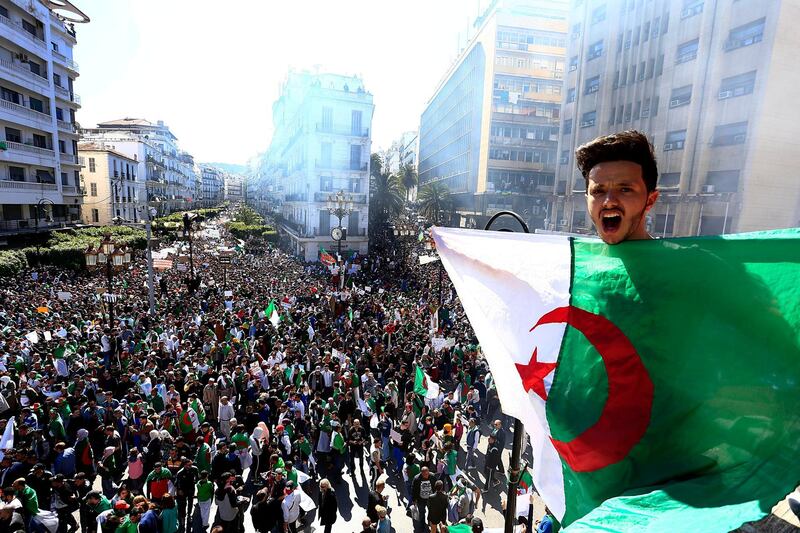Algerian shouts as he holds the national flag during a protest in Algiers, Algeria, Friday, March 15, 2019. Tens of thousands of people gathered Friday in Algeria's capital and other cities amid heavy security for what could be decisive protests against longtime leader Abdelaziz Bouteflika. (AP Photo/Toufik Doudou)