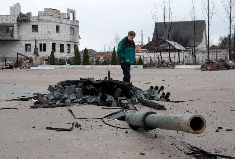 A man examines the debris of a destroyed Russian tank in Bohdanivka. EPA