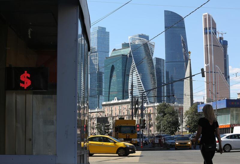 Skyscrapers stand in the Moscow City financial district beyond a currency bureau advertising U.S. dollar exchange rates in Moscow, Russia, on Friday, Aug. 10, 2018. President Vladimir Putin’s efforts to protect Russia after past rounds of U.S. sanctions are leaving the economy more insulated even as the threat of further penalties rattles markets this week. Photographer: Andrey Rudakov/Bloomberg