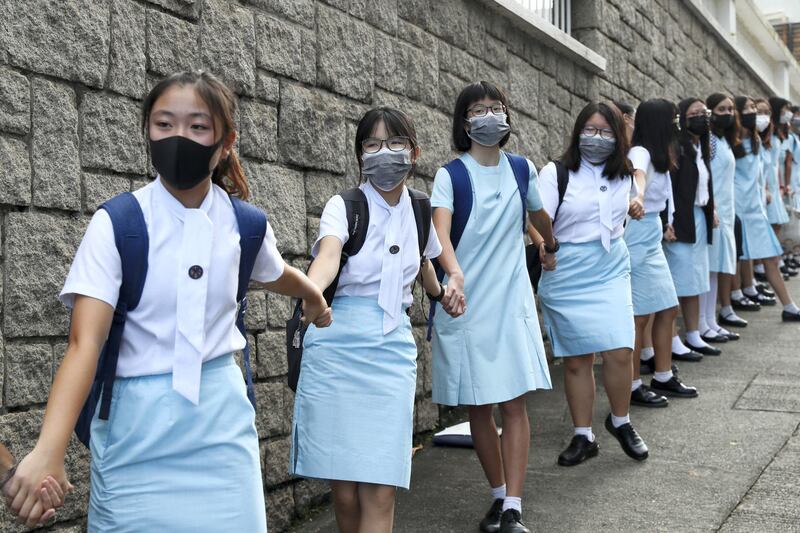 Students form human chain outside the Maryknoll Convent School in Hong Kong, Friday, Sept. 6, 2019. Hong Kong leader Carrie Lam said Thursday that the decision to withdraw an extradition bill that sparked months of demonstrations in the semi-autonomous Chinese territory was her government's own initiative to break the impasse, and not Beijing's directive. (AP Photo/Kin Cheung)