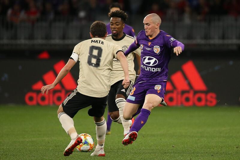 Perth Glory's Neil Kilkenny takes on Angel Gomes and Juan Mata. Getty Images