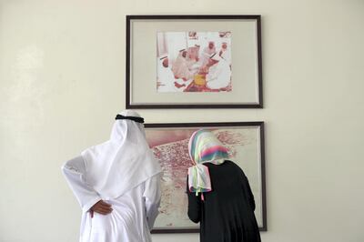 Abu Dhabi, United Arab Emirates - May 3rd, 2018: His Excellency Saqer Al Mehairbi with reporter Haneen Dajani look at a picture of Abu Dhabi in the 60's to go with a story about Ramadan Tents. Thursday, May 3rd, 2018 in Abu Dhabi. Chris Whiteoak / The National
