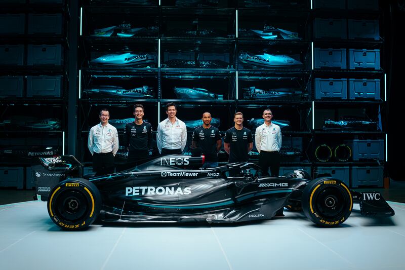Mercedes driver George Russell, second left, team principal Toto Wolff, third left, driver Lewis Hamilton, third right, and reserve driver Mick Schumacher with the new W14 car for the 2023 season. G42 branding will appear on the car. AFP