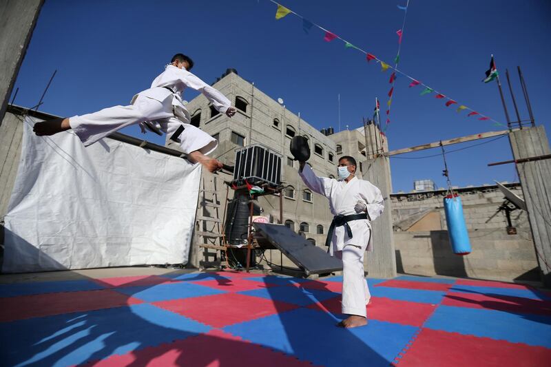 Palestinian Khaled Sheikh el-Eid, a Karate instructor, trains with his son on their home rooftop, amid concerns about the spread of coronavirus, in Rafah in the southern Gaza Strip. Reuters
