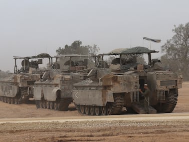 Israeli armoured personnel carriers gather on the Israeli border near the city of Rafah in southern Gaza on Thursday. EPA