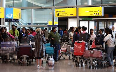 A crowd of people gather at Heathrow Airport in London. The passenger charge made to airlines by Heathrow is largely passed on in ticket prices. EPA / ANDY RAIN