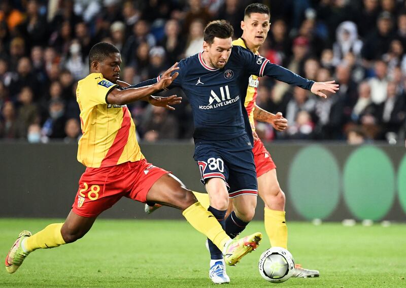 Lionel Messi attempts to ride a challenge from Lens defender Cheick Doucoure. AFP