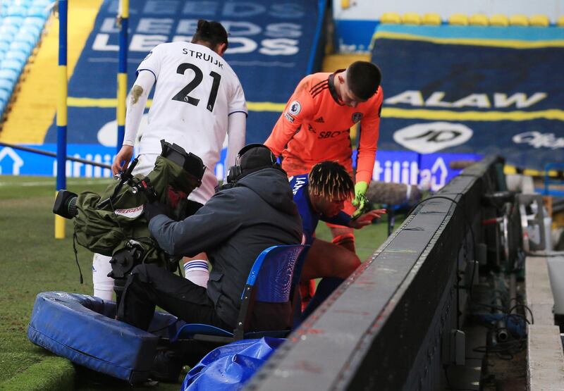 Chelsea's Reece James is helped to his feet by Leeds United's Illan Meslier after falling down. Reuters