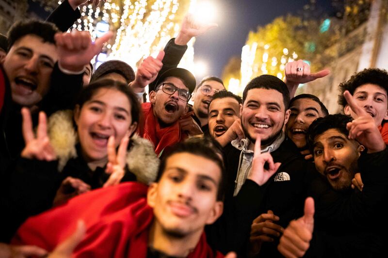 Morocco fans celebrate on the Avenue des Champs-Elysees after their team won the Qatar 2022 World Cup Group F soccer match against Canada in Paris, December 1, 2022.  (Photo by Julie Sebadelha  /  AFP)