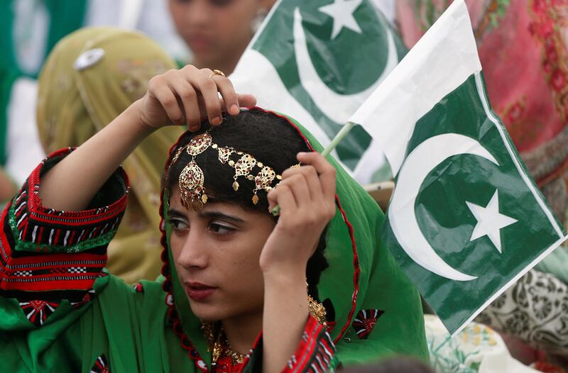A girl holds a national flag as she attends a ceremony in Karachi. Akhtar Soomro / Reuters