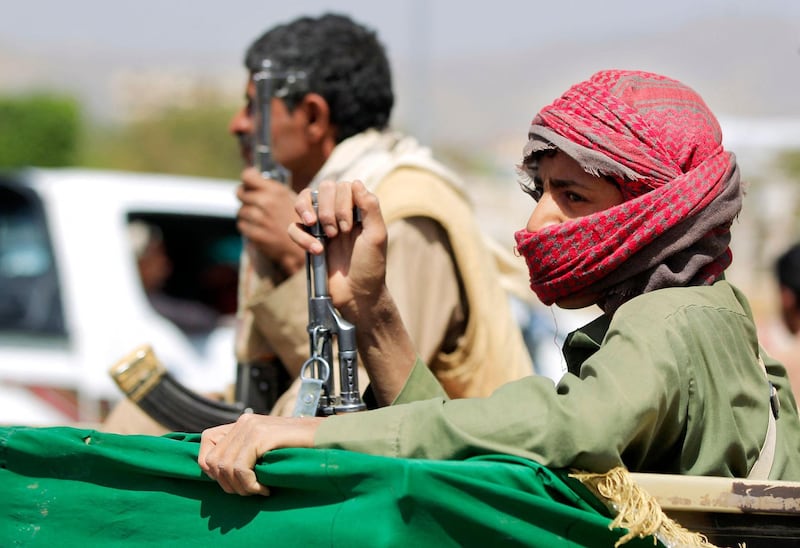 An armed supporter of Yemen's Huthi rebels sits in the back of a pick up during the funeral procession for fighters killed in battles with Saudi-backed government troops in the Marib region, on March 23, 2021 in the capital Sanaa, a day after Saudi Arabia announced a "comprehensive" ceasefire in Yemen. The plan is part of a Saudi peace initiative that also includes a proposal to reopen the international airport in the Yemeni capital, the rebel-held capital, and restart political negotiations between the warring sides.  / AFP / MOHAMMED HUWAIS
