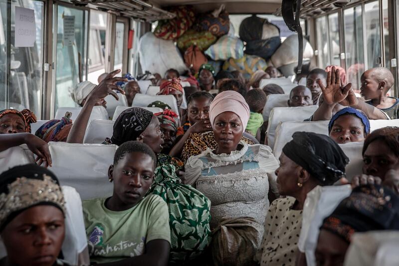 Displaced people who fled Goma on a bus in Sake. They are seen with their belongings, waiting to be taken home. All photos by AFP