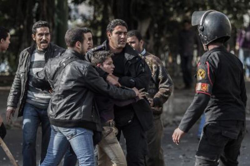 Egyptian security forces detain an anti-government protester during clashes in Cairo on Wednesday. A fight between Egypt's president and the judiciary over elections is likely to heighten tensions in the country. Oliver Weiken / EPA