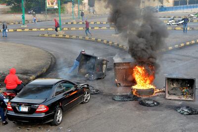 epa08087668 Supporters of outgoing Lebanese Prime Minister Hariri burn dumpsters and tires as they block a main highway in protest against the nomination of Hassan Diab as Prime Minister, in Beirut, Lebanon, 23 December 2019. The newly appointed Lebanese prime minister vowed on 19 December to form a government of experts within six weeks.  EPA/WAEL HAMZEH