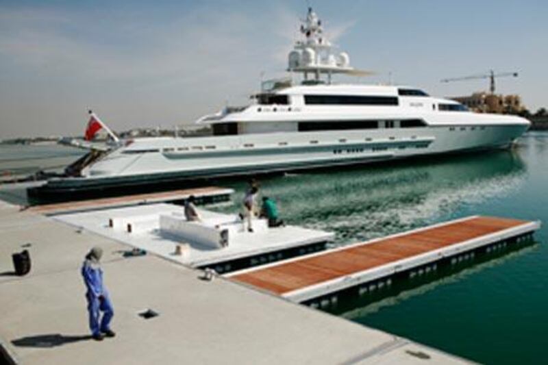Workers prepare the area at the Abu Dhabi National Exhibition Centre as the 'Silver' is docked in the background.
