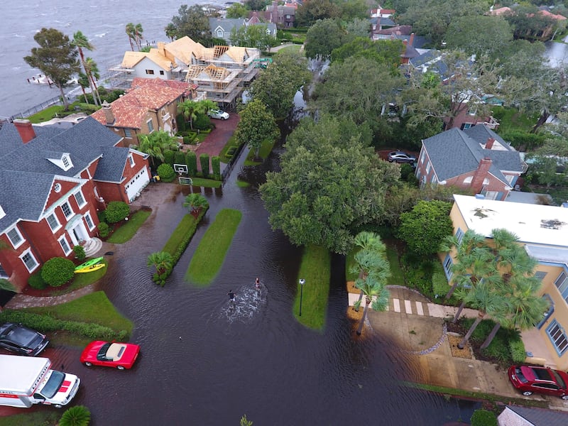 In this Monday, Sept. 11, 2017, photo provided by DroneBase, people trudge through floodwaters in the aftermath of Hurricane Irma in Jacksonville, Fla. In a parting blow to the state, the storm caused record flooding in the Jacksonville area. (DroneBase via AP)