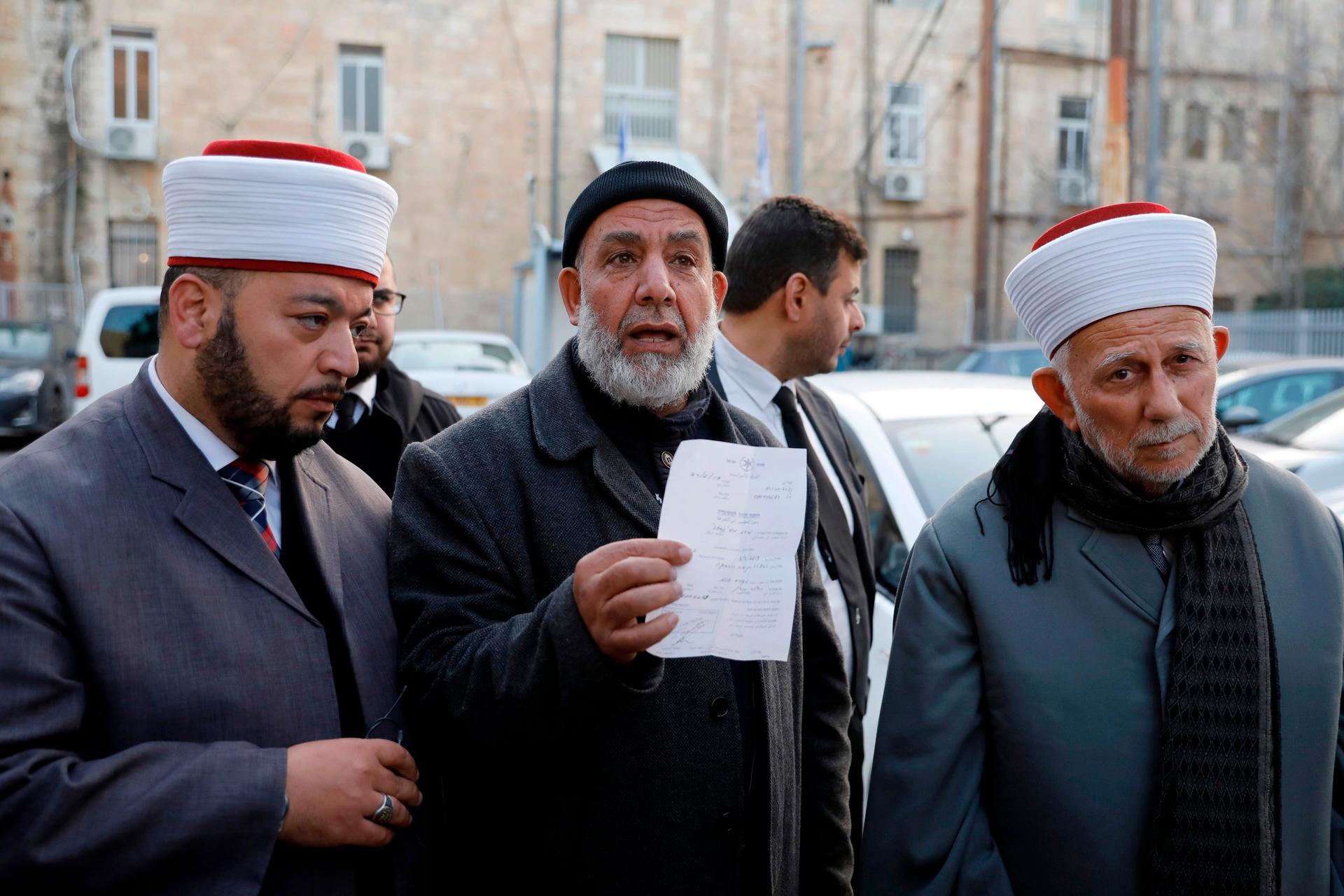 Palestinian head Council of the Waqf Abdel Azeem Salhab (R) and Deputy Director Sheikh Najih Bakirat (C) give a statement after being released from custody in Jerusalem on February 24, 2019. Israeli police said on February 24 they arrested a top Palestinian Muslim official in Jerusalem after scuffles at a flashpoint holy site in the city in the past few days. Israeli police spokesman Micky Rosenfeld said Abdel Azeem Salhab had been arrested for violating an order preventing entry into a prohibited area of the al-Aqsa compound. Salhab, the head of the council of the Waqf in Jerusalem, the religious authority that governs the site, have since been released among others with an order not to visit the holy site. / AFP / AHMAD GHARABLI
