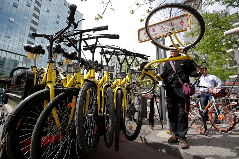 FILE PHOTO - A staff member from the bike-sharing company Ofo gathers its shared bikes for use during the evening rush hour, in Beijing, China April 12, 2017. REUTERS/Jason Lee/File Photo