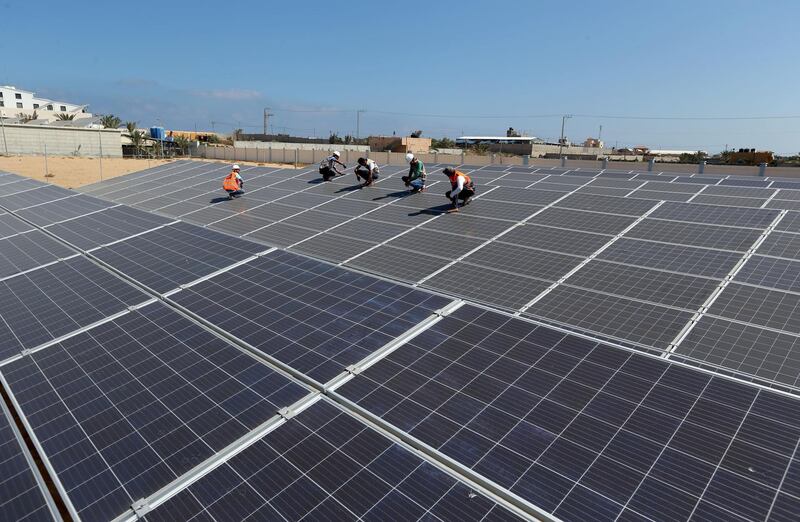 Palestinian workers install solar panels at Khan Younis Waste Water Treatment Plant, in the southern Gaza Strip July 31, 2018. Picture taken July 31, 2018. REUTERS/Ibraheem Abu Mustafa