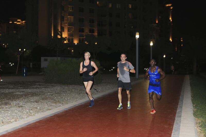 From left, Nike Run Club runners Ea Wederwang, Nicolas Lemaitre and coach Rafael Roots run along the track in Al Ittihad Park on the Palm Jumeirah, Dubai, this week. Sarah Dea / The National 