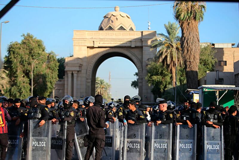 Iraqi security forces stand guard outside the heavily fortified Green Zone during protests in Baghdad. AP
