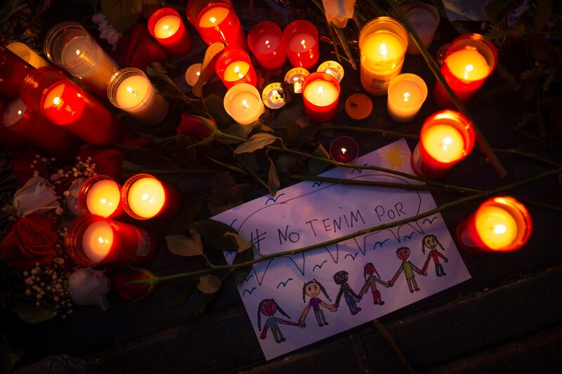 A drawing that reads in Catalan: "We have no fear" is placed among candles and flowers placed on the ground for the victims of an terror attack that left many killed and wounded in Barcelona, Spain, Wednesday, Aug. 23, 2017. Police in northeastern Spain said Wednesday they have found a belt charged with real explosives in a house used by the Barcelona attacks extremist cell. (AP Photo/Francisco Seco)