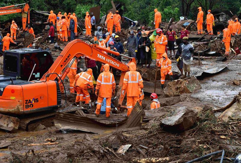Rescue workers search for missing people at a landslide site caused by heavy rains in Pettimudy, in Kerala state.   AFP