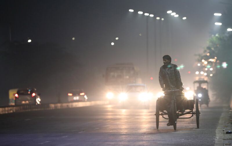 An Indian man on the rickshaw passes over a flyover as the city is engulfed in heavy smog near New Delhi. EPA