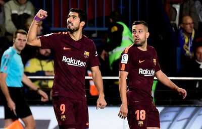 Barcelona's Uruguayan forward Luis Suarez (L) celebrates next to Barcelona's Spanish defender Jordi Alba after scoring during the Spanish league football match between Villarreal CF and FC Barcelona at La Ceramica stadium in Vila-real on December 10, 2017. / AFP PHOTO / JOSE JORDAN