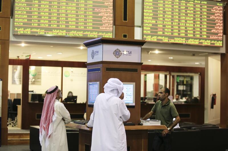 Traders work on the floor at the Dubai Financial Market. UAE stock markers are set for a tricker year according to experts after bumper gains during 2013. Sarah Dea / The National





