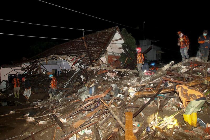 Rescuers search for survivors following a flash flood in which at least five people were killed and four others reported missing in Malang, East Java, Indonesia. AFP