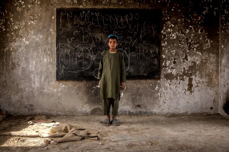 Rahmatullah, 10, poses in a classroom at Shahid Niamatullah Primary School in Panjwayi district, formerly occupied by ISAF and the Afghan National Police. Having lost his father to the war, he says he continues to hear the sounds of bullets at night. 