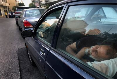 A taxi driver sleeps inside his car as he waits in a long queue for fuel in the Lebanese capital, Beirut. AP
