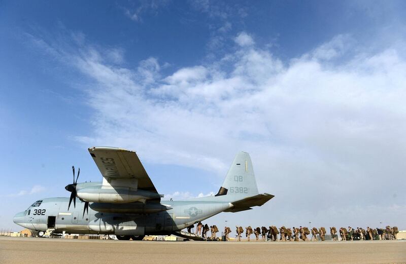 US Marines board a C-130J Super Hercules transport aircraft headed to Kandahar as British and US forces withdraw from the Camp Bastion-Leatherneck complex at Lashkar Gah in Helmand province on October 27, 2014. British forces October 26 handed over formal control of their last base in Afghanistan to Afghan forces, ending combat operations in the country after 13 years which cost hundreds of lives. The Union Jack was lowered at Camp Bastion in the southern province of Helmand, while the Stars and Stripes came down at the adjacent Camp Leatherneck -- the last US Marine base in the country. AFP PHOTO/WAKIL KOHSAR (Photo by WAKIL KOHSAR / AFP)