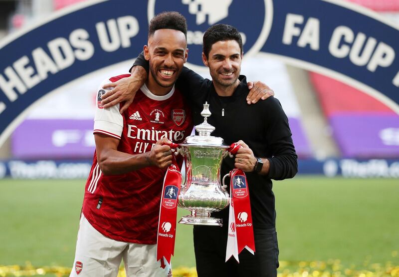 FILE PHOTO: Soccer Football - FA Cup Final - Arsenal v Chelsea - Wembley Stadium, London, Britain - August 1, 2020 Arsenal manager Mikel Arteta and Pierre-Emerick Aubameyang celebrate with the trophy after winning the FA Cup, as play resumes behind closed doors following the outbreak of the coronavirus disease (COVID-19) Pool via REUTERS/Catherine Ivill/File Photo