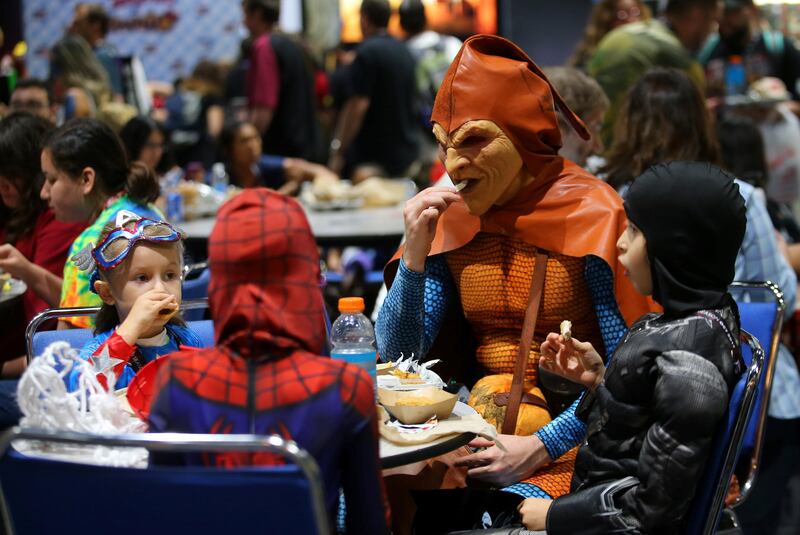 Andre Rhoden, dressed as the Hobgoblin, takes the children to lunch on the floor at Comic Con International in San Diego. Mike Blake / Reuters