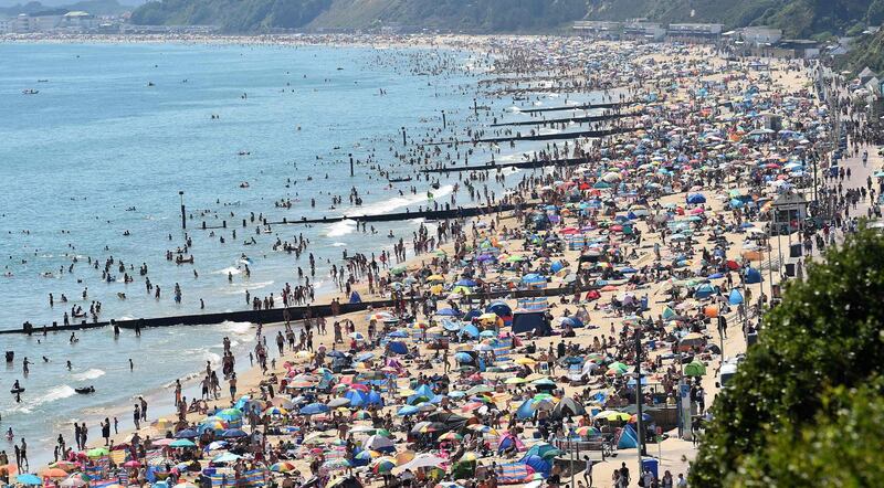 Beachgoers enjoy the sunshine as they sunbathe and play in the sea on Bournemouth beach, southern England after coronavirus restrictions eased in the UK. AFP