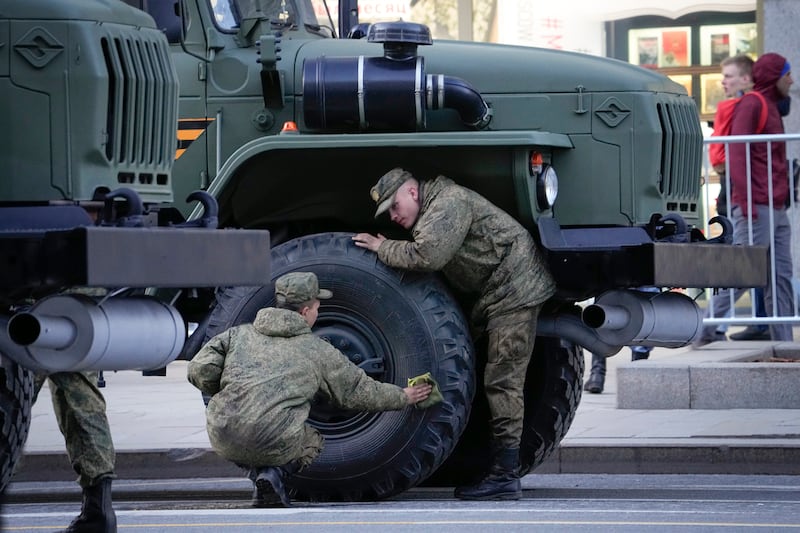 Russian soldiers clean their vehicle before the rehearsal. AP 