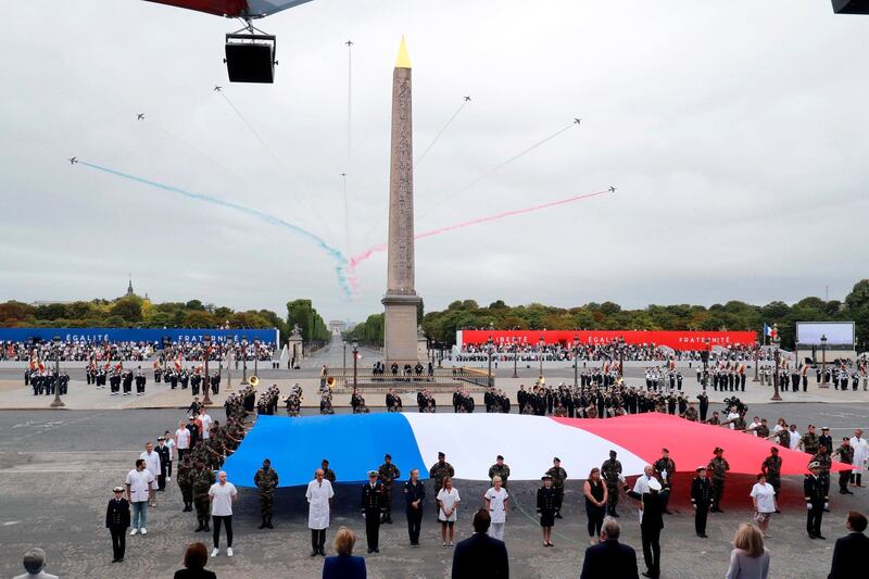Members of medical staff pose with the French flag as they take part in the annual Bastille Day ceremony on the Place de la Concorde in Paris. AP