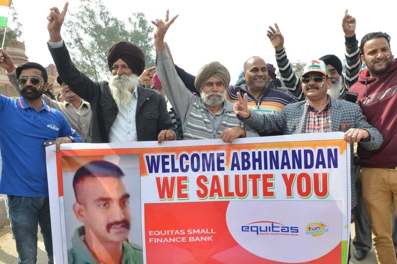 TOPSHOT - People shout slogans near the India-Pakistan border in Wagah on March 1, 2019, as they wait for the return of an Indian Air Force pilot being returned by Pakistan. A pilot shot down in a dogfight with Pakistani aircraft returned to India on Friday, after being freed in what Islamabad called a "peace gesture" following the biggest standoff between the two countries in years. But fresh violence raged in Kashmir, with 11 people killed in the Indian-administered part of the tinder-box territory, suggesting that the spike in tensions sparked by the death of 40 Indian soldiers in a suicide bombing last month may not be over.
 / AFP / NARINDER NANU
