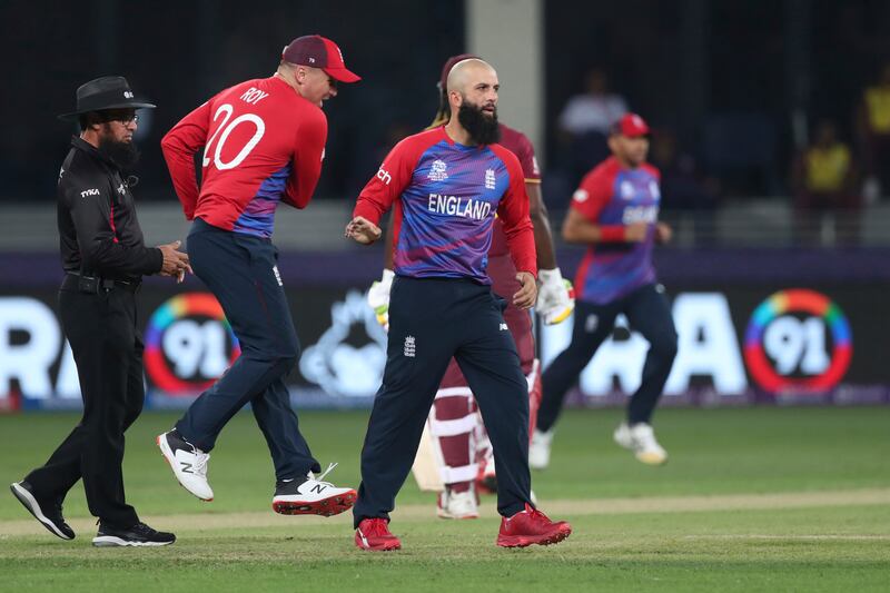 England's Moeen Ali, right, celebrates after taking the wicket of West Indies' Lendl Simmons caught by England's Liam Livingstone during the Cricket T20 World Cup match between England and the West Indies at the Dubai International Cricket Stadium, in Dubai, UAE, Saturday, Oct.  23, 2021.  (AP Photo / Aijaz Rahi)