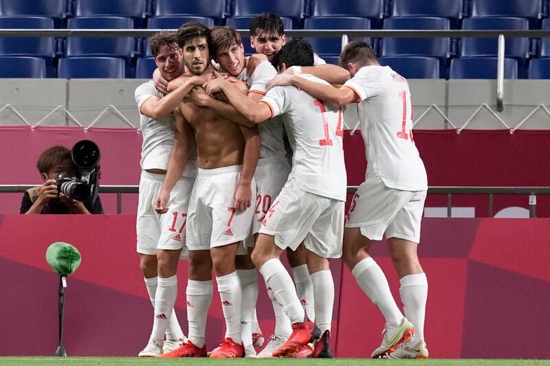 Marco Asensio is mobbed by Spain teammates after his late winning goal against Japan in the Olympics semi-finals.