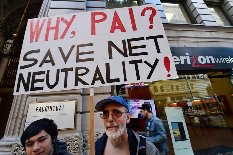 A small group of protestors supporting net neutrality protest against a plan by Federal Communications Commission (FCC) head Ajit Pai, during a protest outside a Verizon store on December 7, 2017 in Los Angeles, California.  
Demonstrations in support of net neutrality are planned nation-wide at hundreds of Verizon stores and other venues. / AFP PHOTO / Robyn Beck