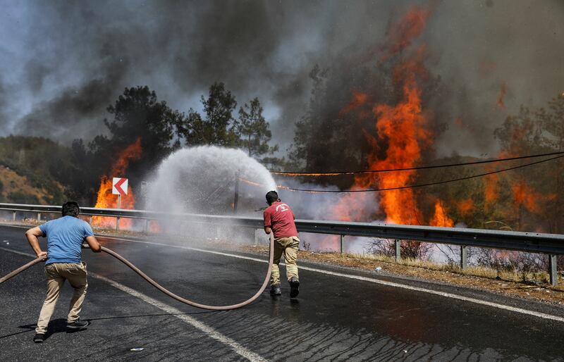 Firefighters and volunteers try to extinguish a fire near Marmaris.
