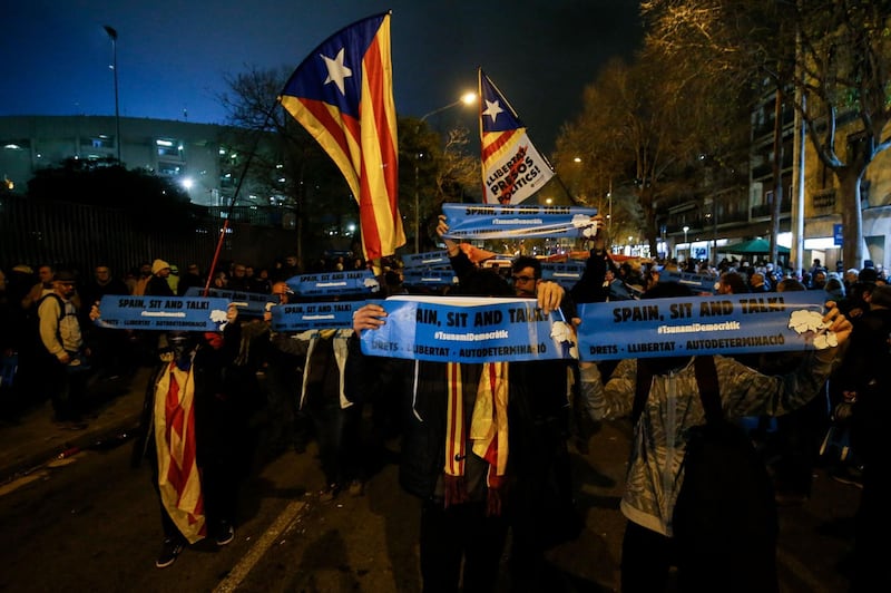 Demonstrators wave Catalan pro-independence "Estelada" flags and placards reading "Spain, Sit and Talk" outside the Camp Nou stadium in Barcelona. AFP