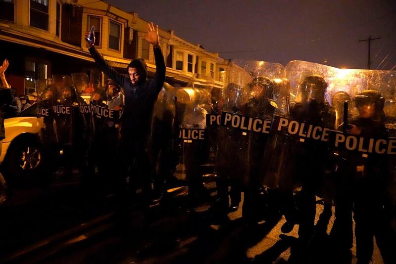 Sharif Proctor lifts his hands up in front of the police line during a protest in response to the police shooting of Walter Wallace Jr. in Philadelphia.AP